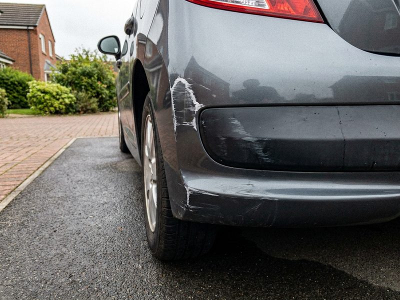 Dark grey bumper corner with white scuff marks before SMART repair