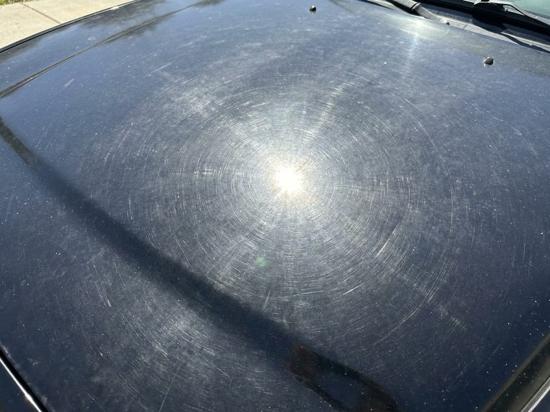 Swirled black paint before machine polishing