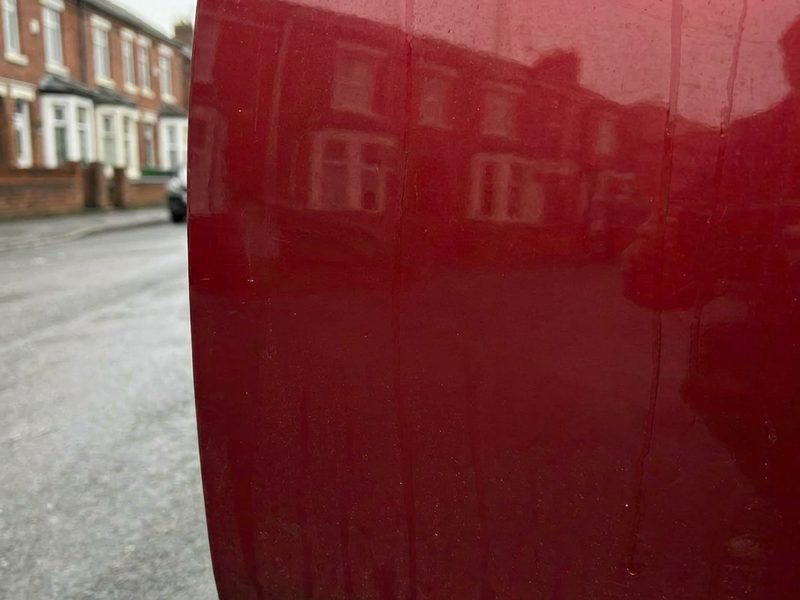 Repaired glossy red door panel
